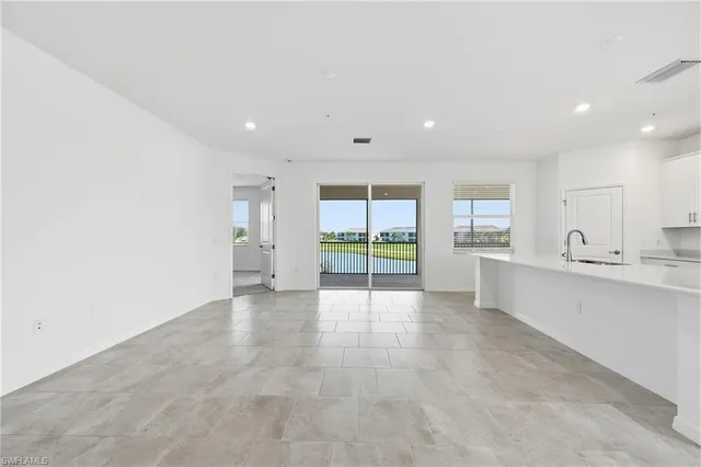 a view of an empty room with a kitchen