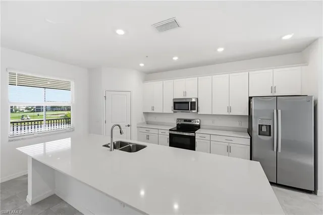 a kitchen with stainless steel appliances a refrigerator sink and stove