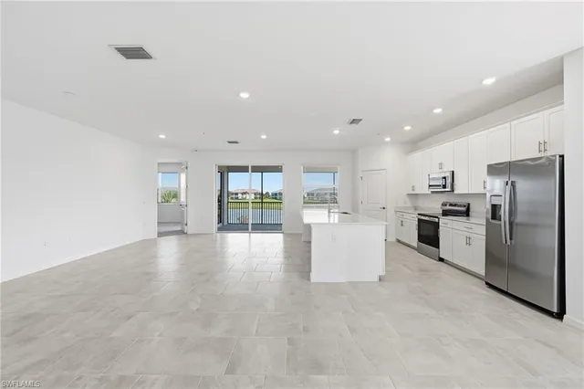 a view of kitchen with kitchen island and stainless steel appliances