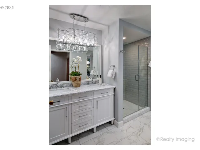 a bathroom with a granite countertop sink a large mirror and shower