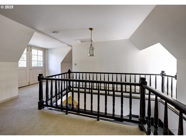 a view of staircase with lots of frames on wall and a window