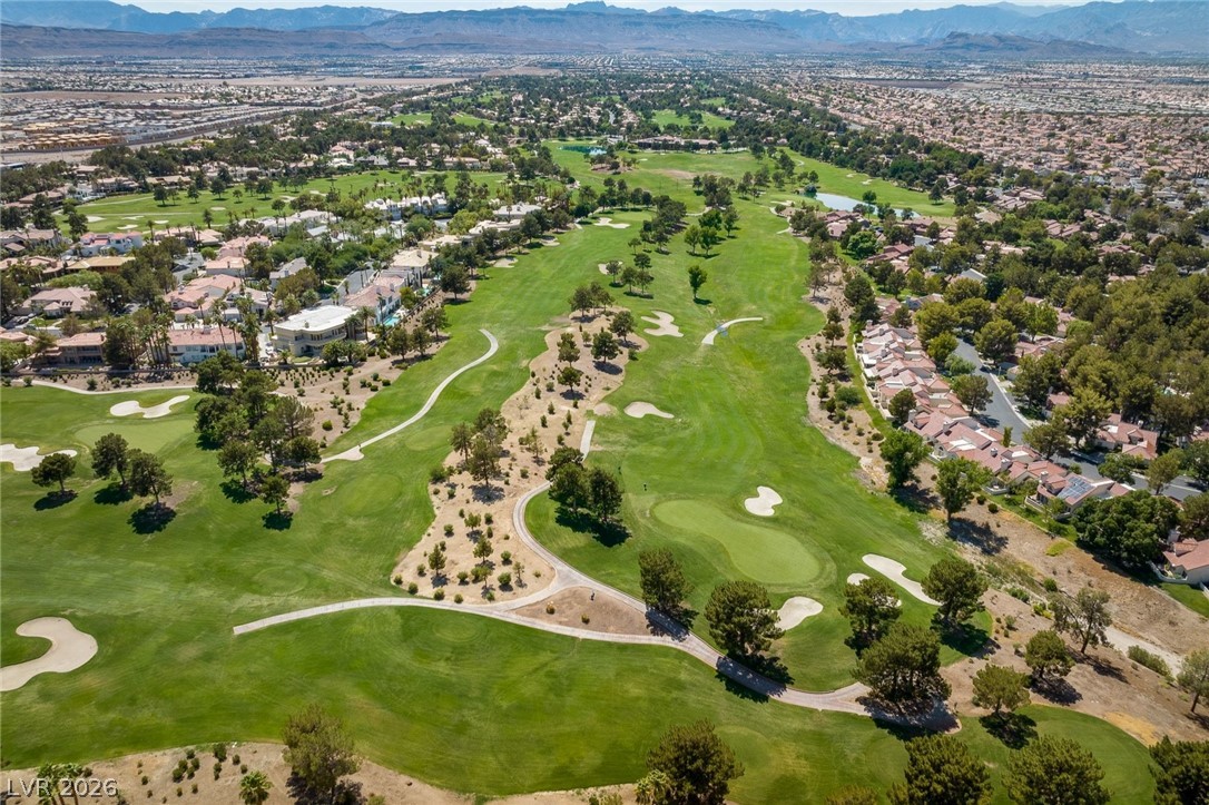 20 Innisbrook Avenue Las Vegas, NV 89113 - Photo 20 of 39 A sweeping aerial view reveals a verdant golf course winding through a residential community with distant mountain ranges.