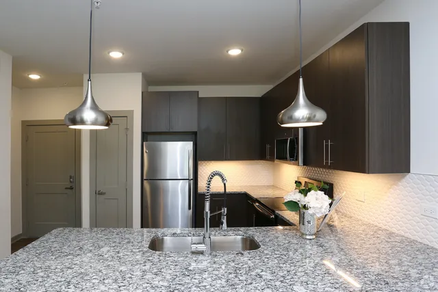 a kitchen with a chandelier a refrigerator and a sink