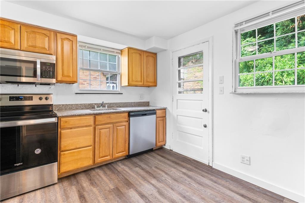 156 Lebeau Pittsburgh, PA 15221 - Photo 5 of 40 a kitchen with stainless steel appliances granite countertop a stove a sink and a microwave