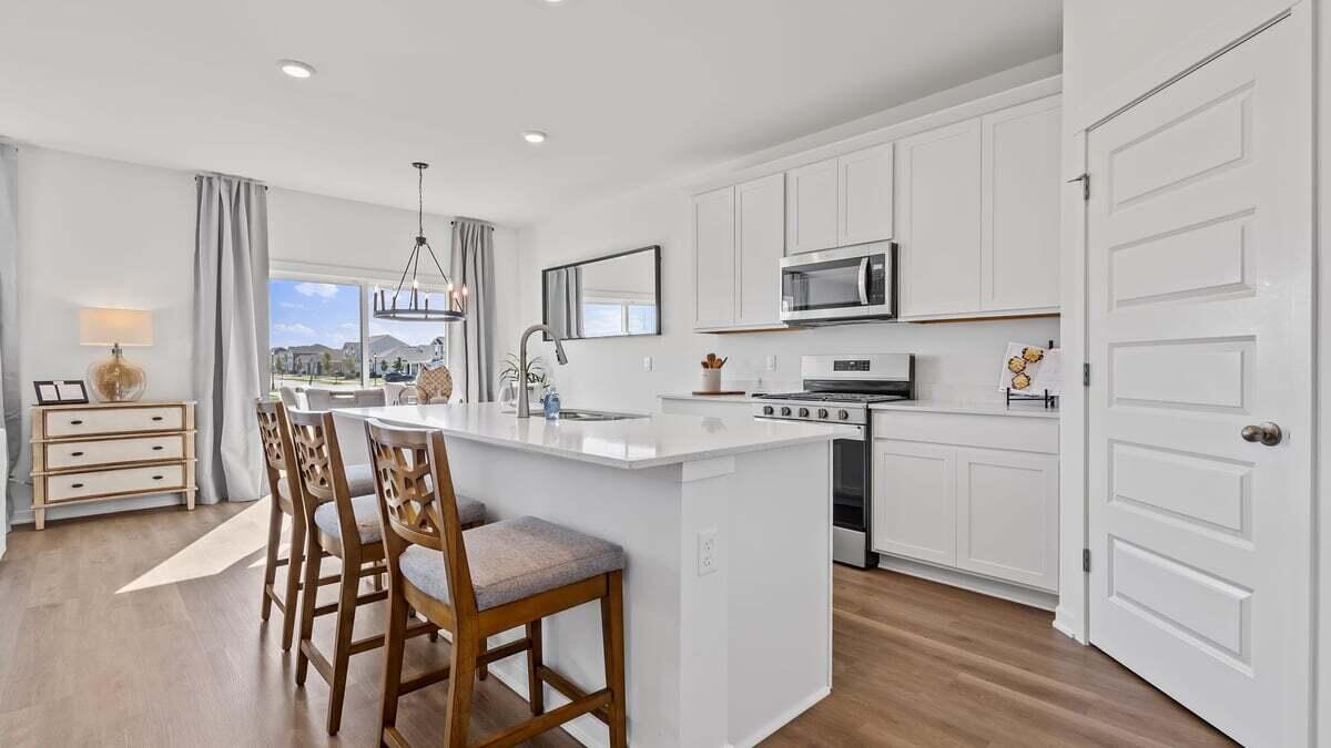 7653 West 106th Place Crown Point, IN 46307 - Photo 2 of 55 a kitchen with a table chairs refrigerator and cabinets