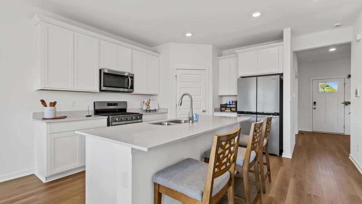 7653 West 106th Place Crown Point, IN 46307 - Photo 3 of 55 a kitchen with stainless steel appliances a sink a stove a refrigerator cabinets and a dining table