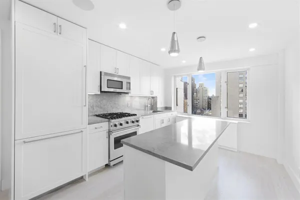 a large kitchen with granite countertop a stove and a refrigerator