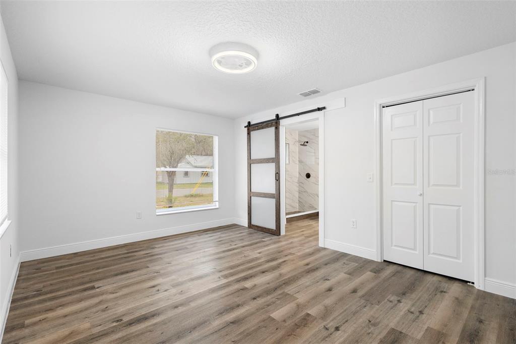 860 South Grove Street Eustis, FL 32726 - Photo 18 of 54 a view of an empty room with wooden floor and a window