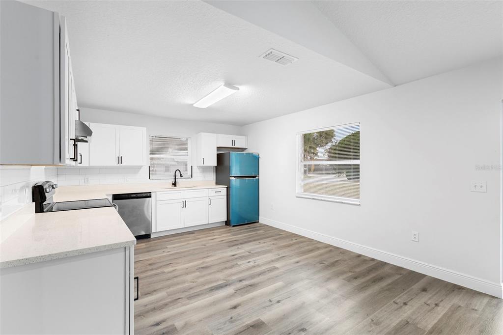 860 South Grove Street Eustis, FL 32726 - Photo 51 of 54 a kitchen with a stove a sink a refrigerator white cabinets and wooden floor