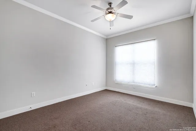 an empty room with a window and a fan