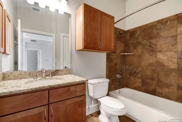 a bathroom with a granite countertop sink toilet and shower
