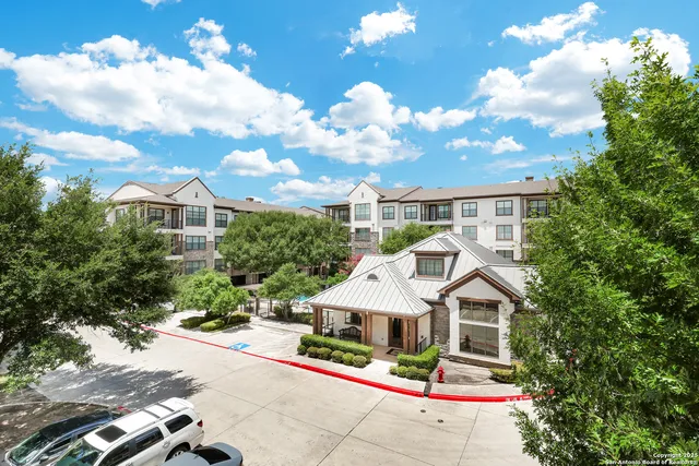 a white house with a small yard and potted plants