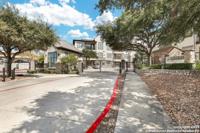 a front view of a building with large trees