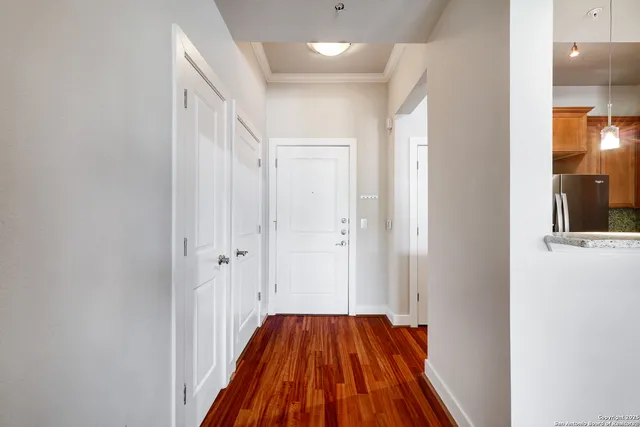 a view of a hallway with wooden floor and staircase