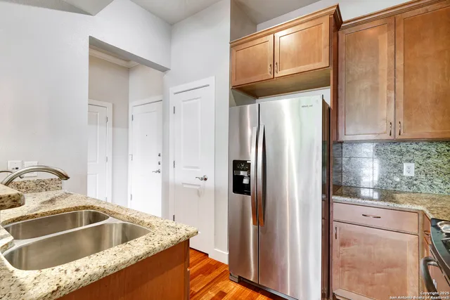 a kitchen with granite countertop a refrigerator and a sink