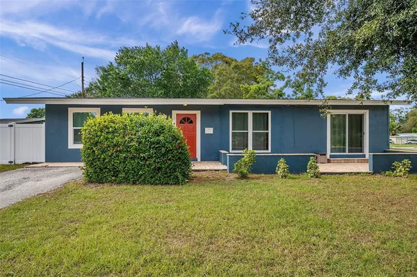 a view of a house with a yard and potted plants