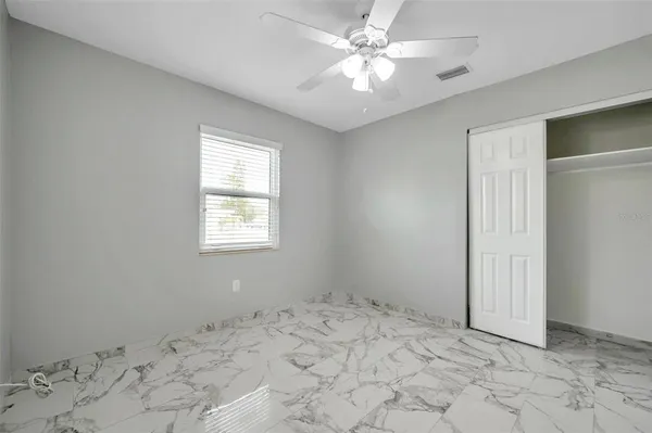 a view of a room with a chandelier fan and closet