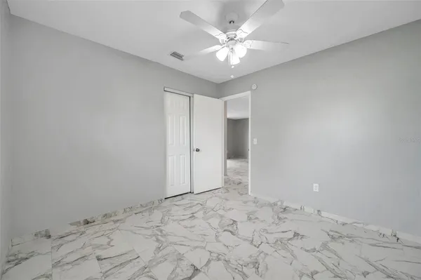 a view of a big room with closet and a ceiling fan view