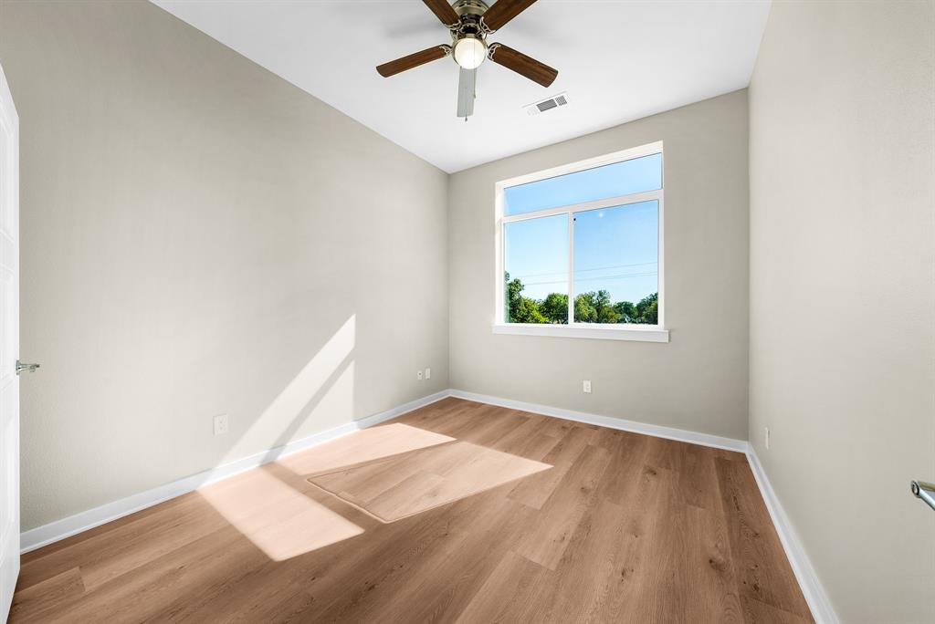 3522 Main Street, Unit 203 Rowlett, TX 75088 - Photo 11 of 20 an empty room with wooden floor fan and windows