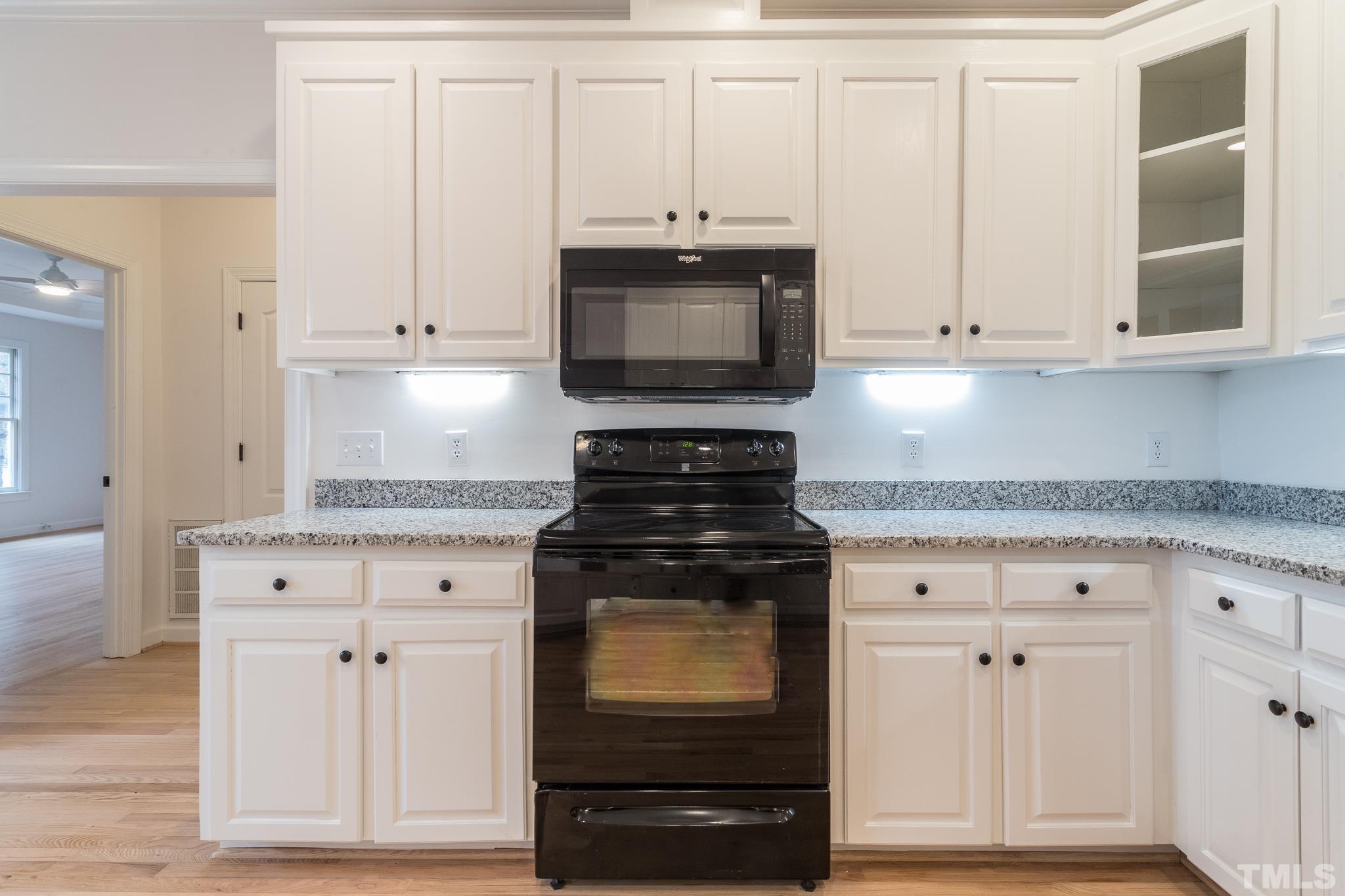 2308 Hideaway Court Raleigh, NC 27613 - Photo 13 of 43 a kitchen with white cabinets and black appliances