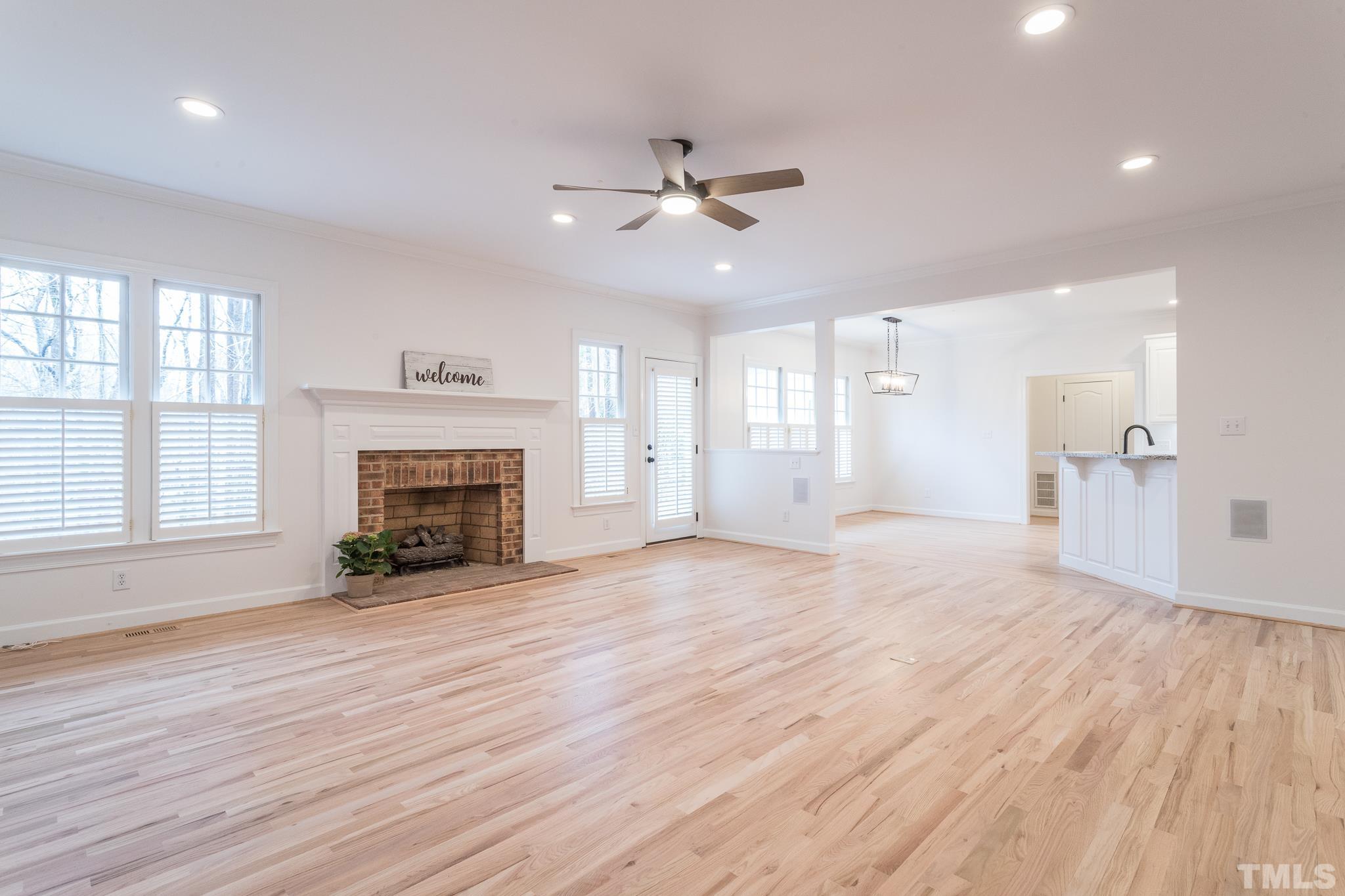 2308 Hideaway Court Raleigh, NC 27613 - Photo 16 of 43 an empty room with wooden floor a fireplace and windows
