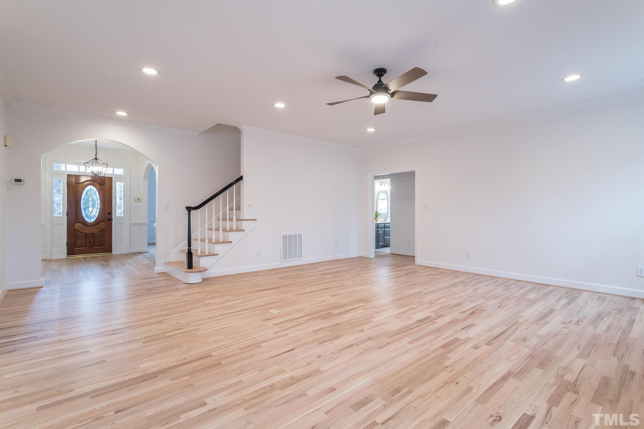 2308 Hideaway Court Raleigh, NC 27613 - Photo 4 of 43 a view of an empty room with wooden floor and a ceiling fan