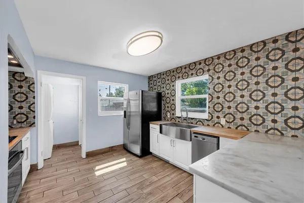 a kitchen with stainless steel appliances granite countertop a refrigerator and a stove top oven