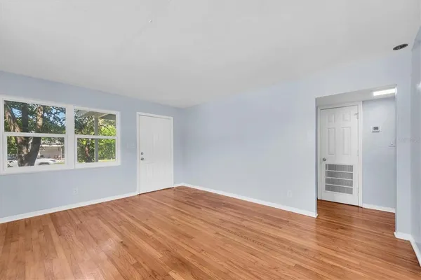 a view of a room with wooden floor and windows