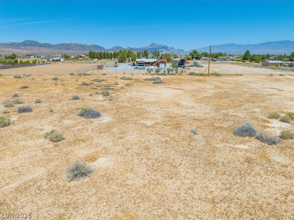 4580 Lawrence Road Pahrump, NV 89048 - Photo 14 of 40 A vast, level lot awaits your vision, framed by distant mountains under an open sky.