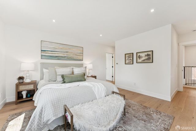 a bedroom with a bed and a lamp with wooden floor