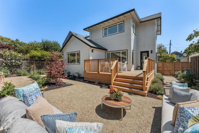 a view of a house with backyard and sitting area