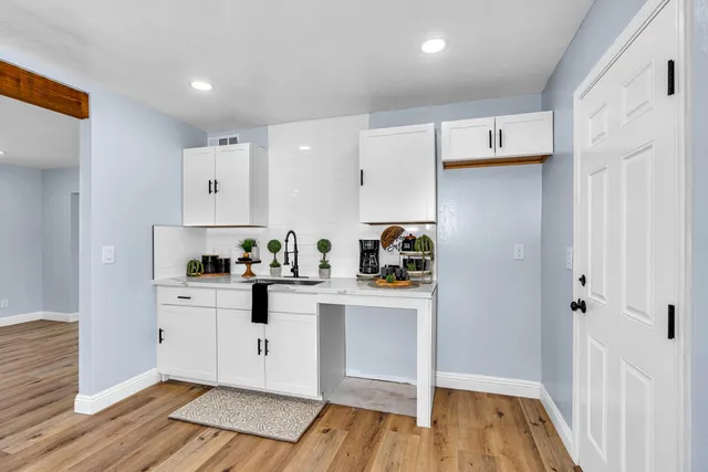 a view of a big room with wooden floor and windows