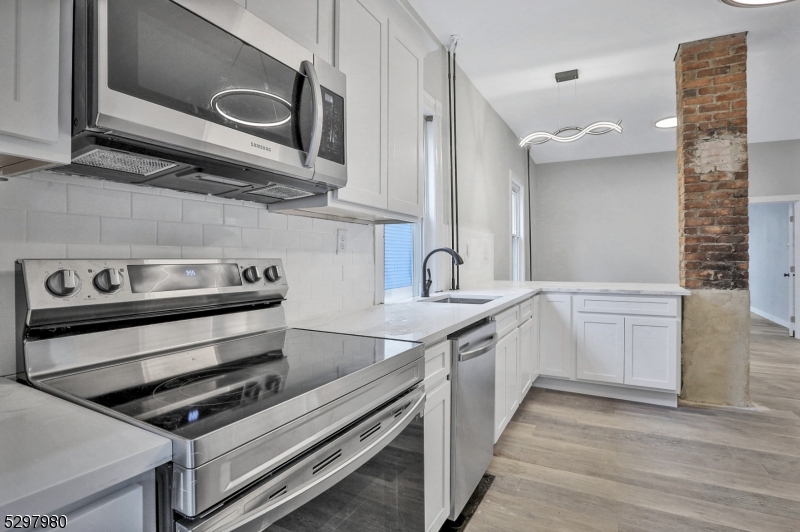 25 Kiel Avenue, Unit 1 Butler, NJ 07405 - Photo 11 of 23 a kitchen with stainless steel appliances granite countertop a stove and a sink