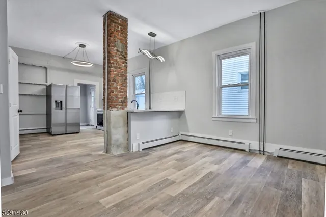 an empty room with wooden floor and a window