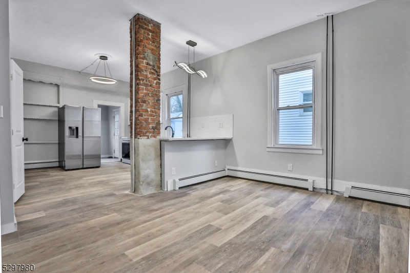 25 Kiel Avenue, Unit 1 Butler, NJ 07405 - Photo 6 of 23 an empty room with wooden floor and a window