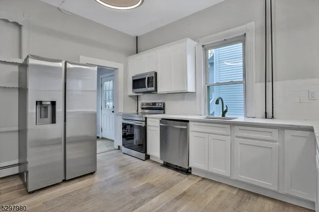 a kitchen with a refrigerator stove and sink