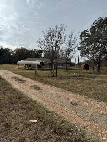a view of a yard with wooden fence
