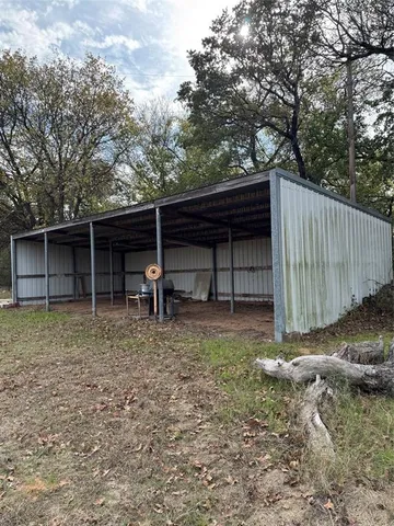 a view of backyard and wooden fence