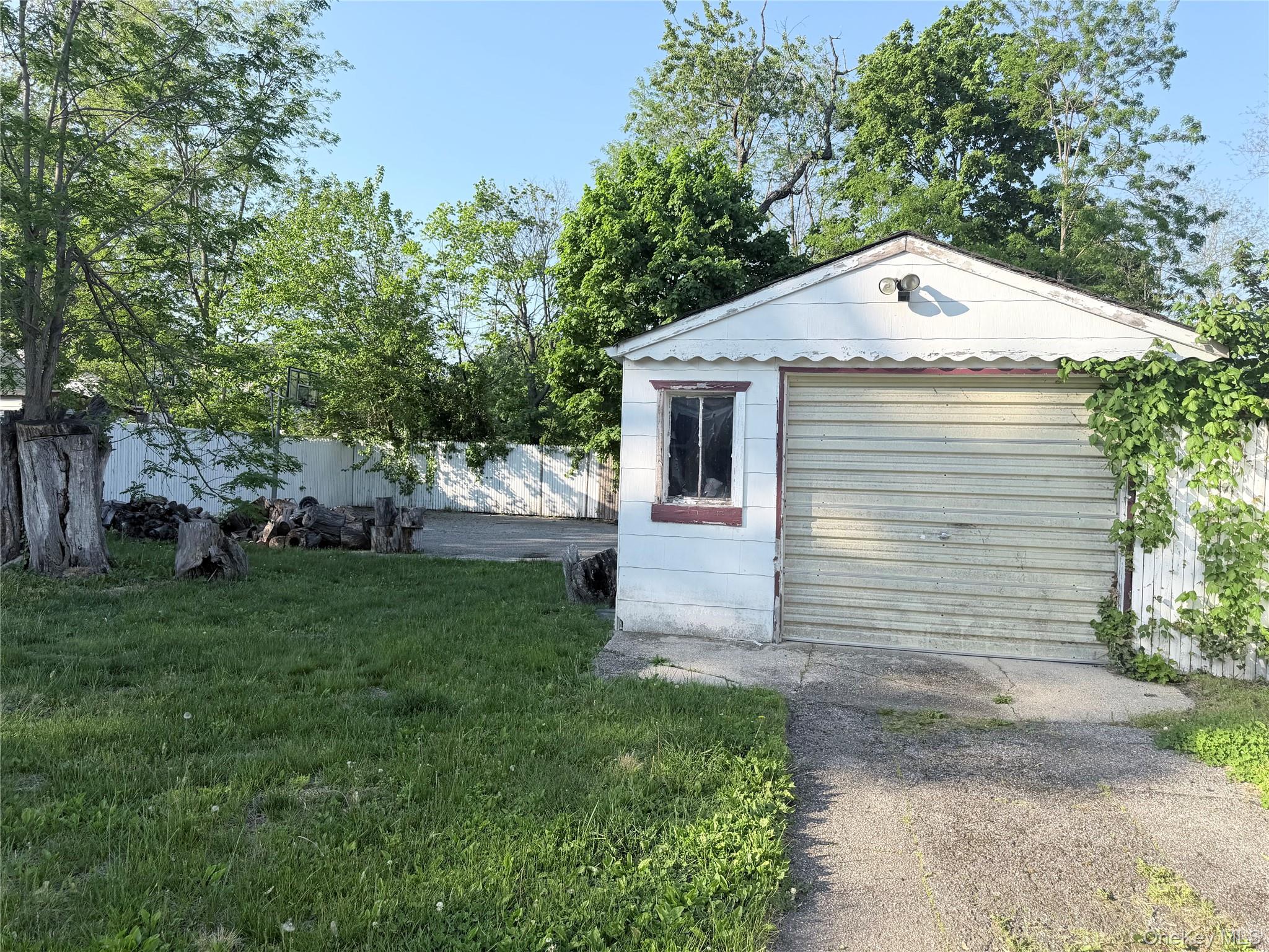 43 Bethpage Road Copiague, NY 11726 - Photo 3 of 3 Detached garage structure featuring a roll-up door and a single-pane window