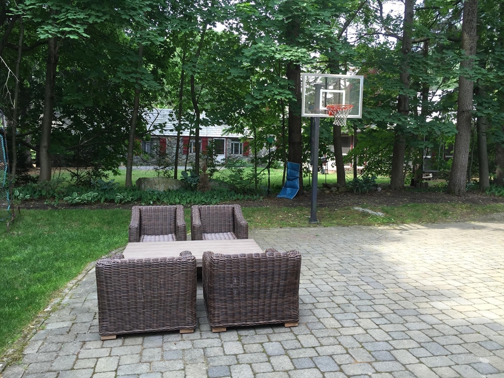 225 Arnold Road Newton, MA 02459 - Photo 20 of 20 a view of a patio with table and chairs and a large tree