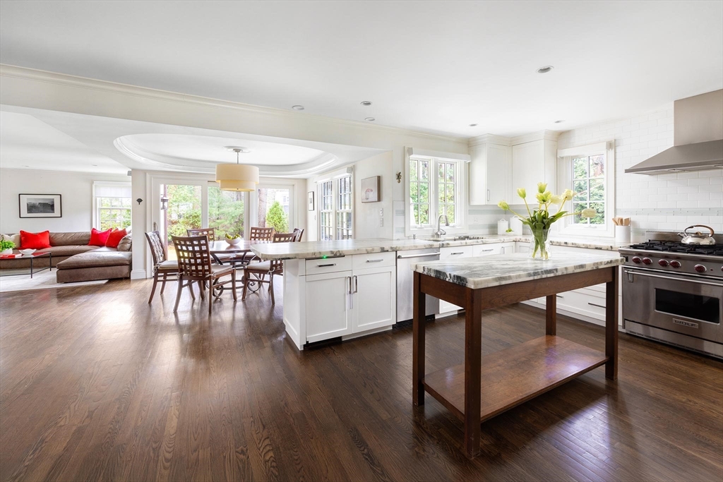225 Arnold Road Newton, MA 02459 - Photo 6 of 20 a kitchen with stainless steel appliances granite countertop wooden floors stove top oven and cabinets