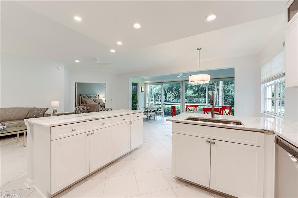 23136 Rosedale Drive, Unit 102 Estero, FL 34135 - Photo 12 of 32 a kitchen that has a lot of cabinets in it and wooden floors