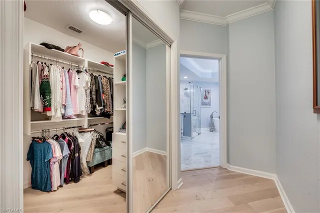 a view of walk in closet with clothes and shoes