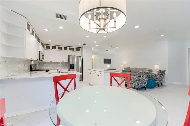 an entryway with a chandelier and a view of kitchen
