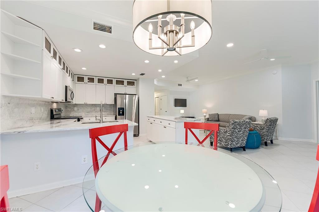 23136 Rosedale Drive, Unit 102 Estero, FL 34135 - Photo 10 of 32 an entryway with a chandelier and a view of kitchen