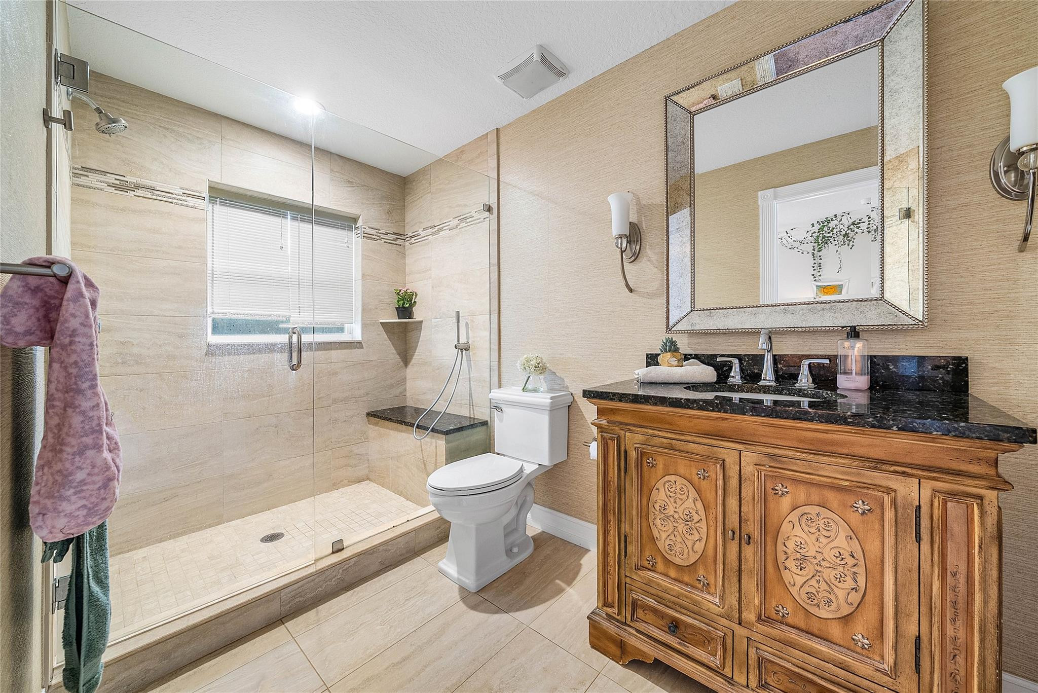 8035 Dillman Road West Palm Beach, FL 33411 - Photo 35 of 70 a bathroom with a granite countertop sink a toilet a mirror a vanity a bathtub and shower