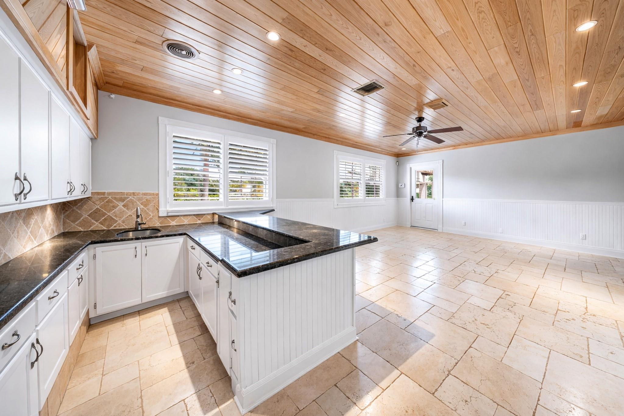 8035 Dillman Road West Palm Beach, FL 33411 - Photo 48 of 70 a kitchen with granite countertop a sink and a stove