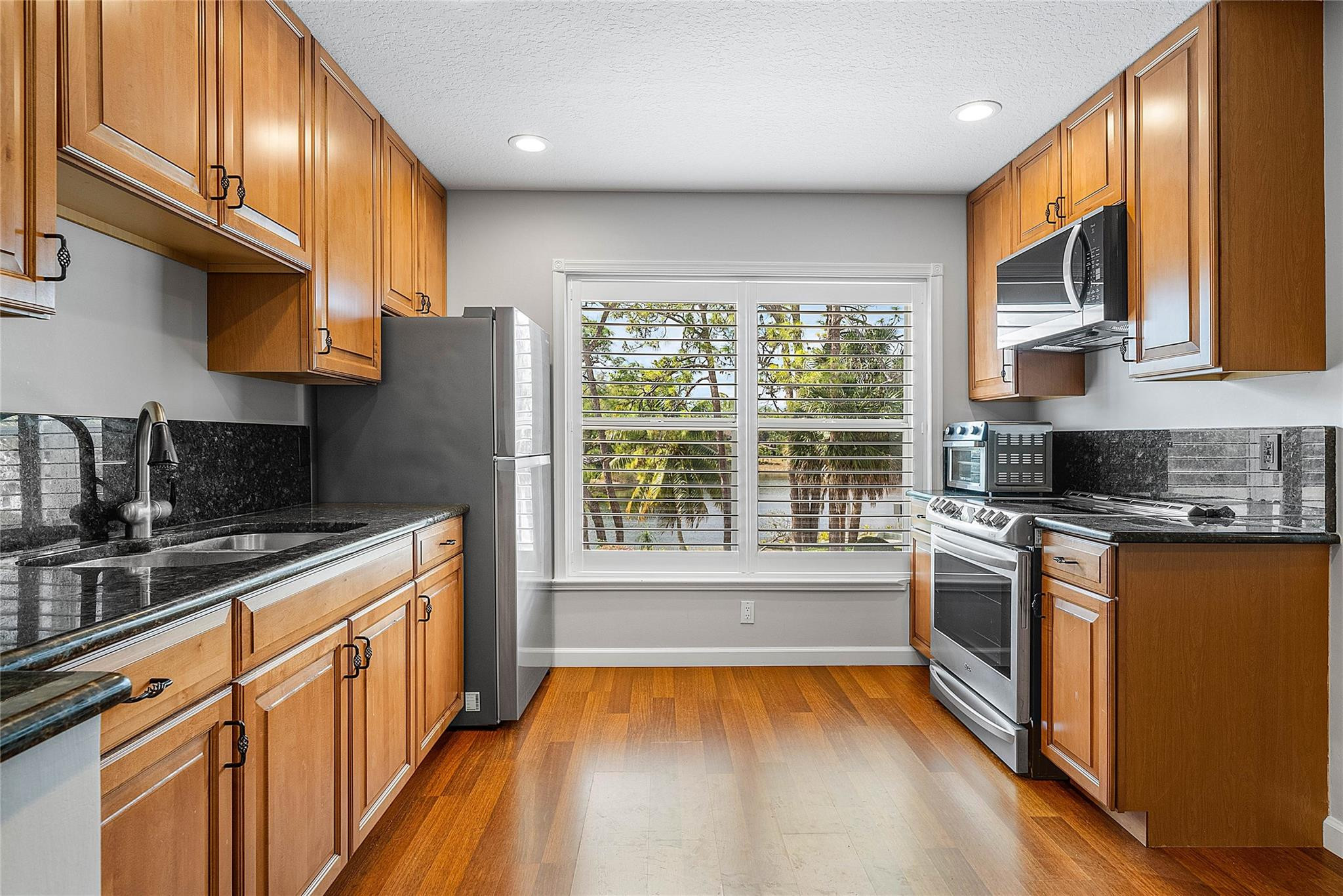 8035 Dillman Road West Palm Beach, FL 33411 - Photo 53 of 70 a kitchen with stainless steel appliances granite countertop a stove a sink and a refrigerator