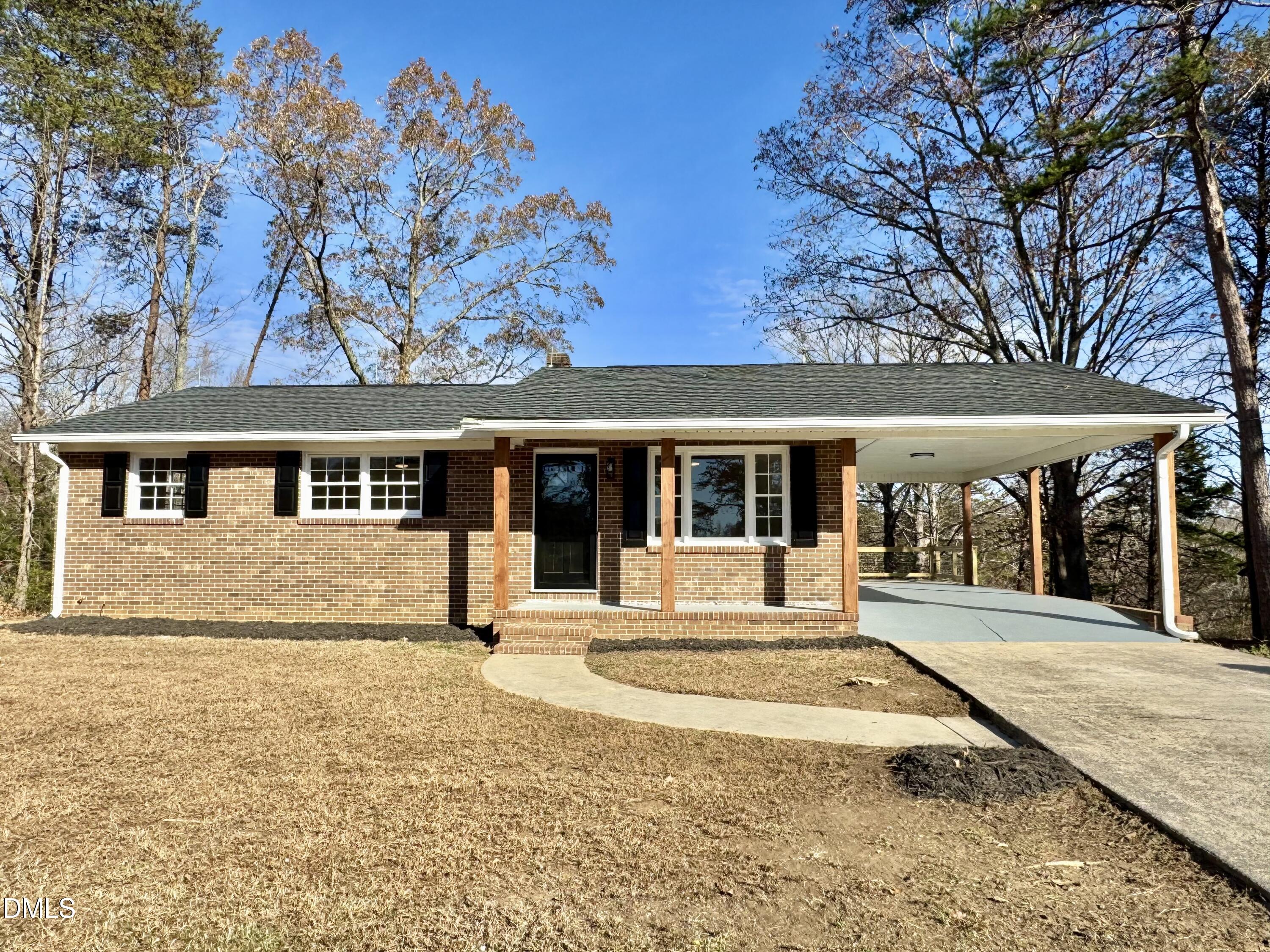 a front view of a house with a yard outdoor seating and covered with snow