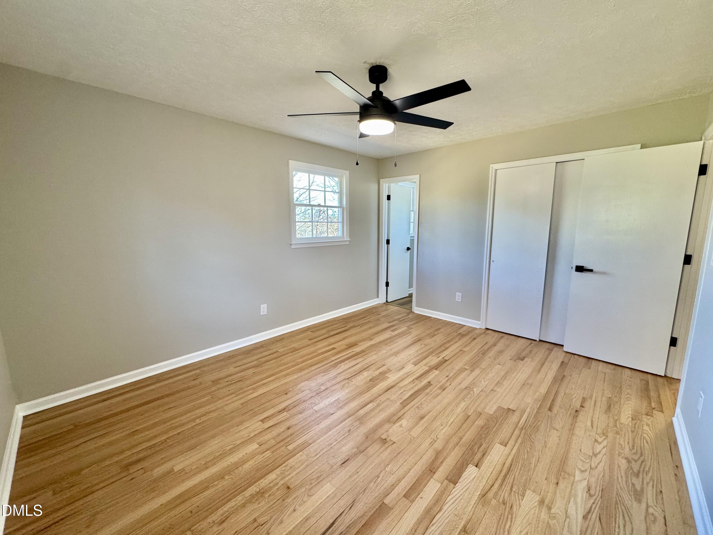 727 High Rock School Road Blanch, NC 27212 - Photo 16 of 29 a view of empty room with wooden floor and fan